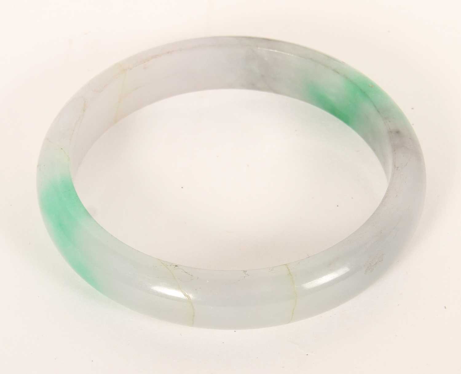 Lot 291 - A jade coloured hardstone bangle, internal...