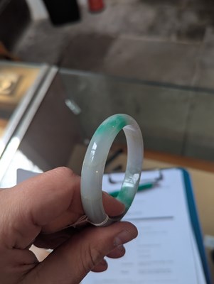 Lot 291 - A jade coloured hardstone bangle, internal...