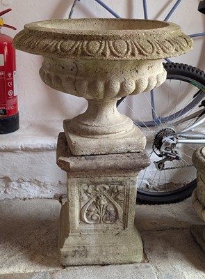 Lot 526 - A reconstituted stone garden urn on a plinth