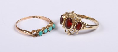 Lot 233 - A 9ct yellow gold three stone garnet ring,...
