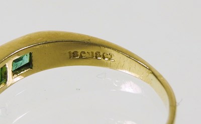 Lot 27 - An 18 carat gold diamond and emerald ring, the...
