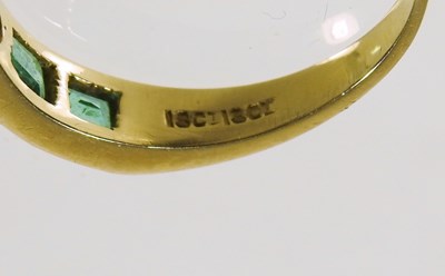 Lot 27 - An 18 carat gold diamond and emerald ring, the...