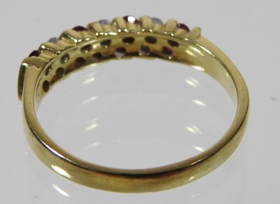Lot 13 - An 18 carat gold, ruby and diamond half-hoop eternity ring