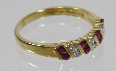 Lot 13 - An 18 carat gold, ruby and diamond half-hoop eternity ring