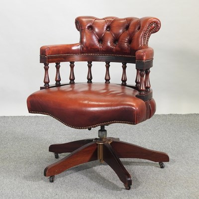 Lot 668 - A red leather upholstered swivel desk chair