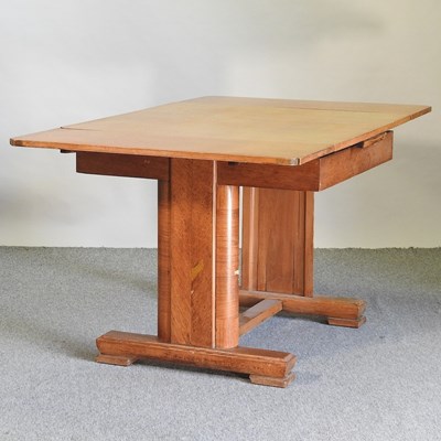 Lot 716 - An Art Deco light oak draw leaf dining table