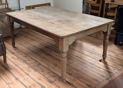 Lot 399 - A large pine dining table, standing on turned...