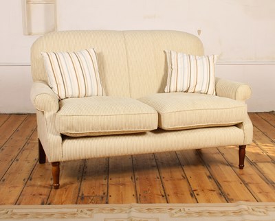 Lot 601 - A cream upholstered two seater sofa