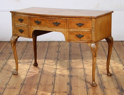 Lot 611 - A reproduction walnut bow front dressing table