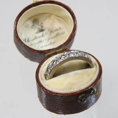 Lot 19 - An 18 carat white gold diamond half hoop eternity ring