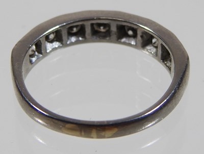 Lot 19 - An 18 carat white gold diamond half hoop eternity ring