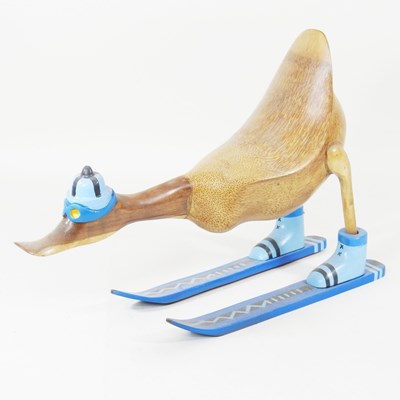 Lot 454 - A wooden carving of a skiing duck, 45cm long