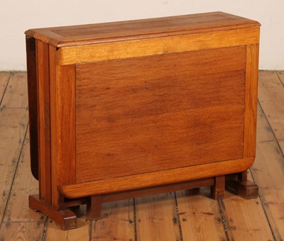 Lot 413 - A 1930s oak drop leaf dining table, having...