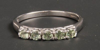 Lot 24 - A 9 carat white gold green amethyst five stone...