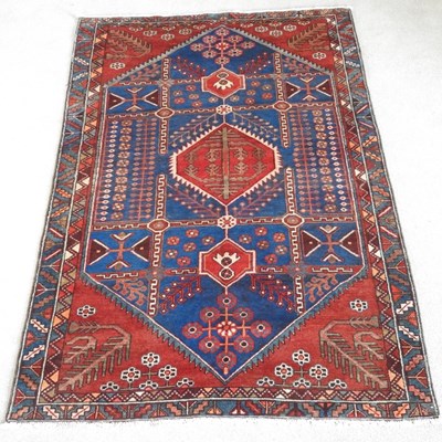 Lot 381 - A Persian rug, with hooked motifs, on a blue...