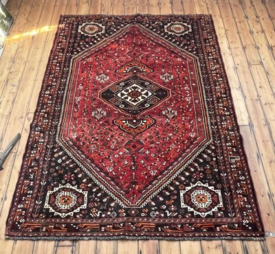 Lot 64 - A Persian Qashgai carpet, on a red ground, 312...