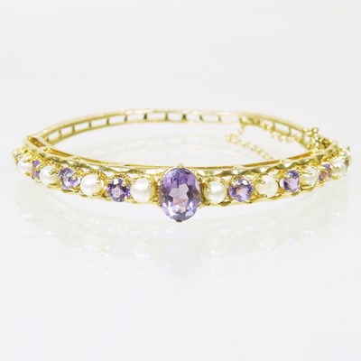 Lot 103 - A 9 carat gold pearl and amethyst bangle, set...