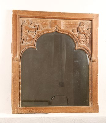 Lot 667 - A carved oak wall mirror, relief decorated...