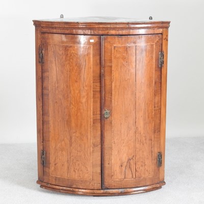 Lot 291 - An 18th century walnut bow front hanging...