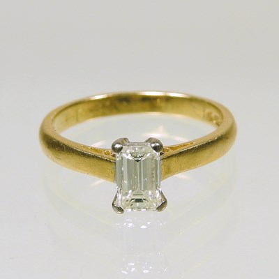 Lot 192 - An 18 carat gold diamond ring, with an emerald...