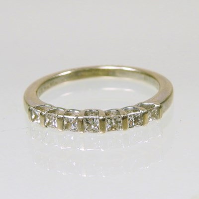 Lot 321 - An 18 carat white gold seven stone half hoop...