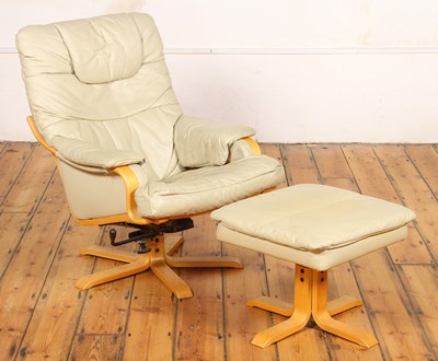 Lot 624 - A beige upholstered leather swivel lounge...