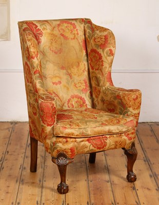 Lot 354 - A Georgian style wing armchair, on shell...