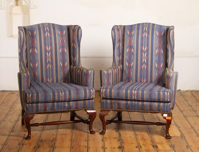 Lot 774 - A pair of blue upholstered wing armchairs, on...