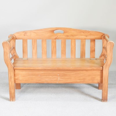 Lot 114 - A stained pine settle, with a rising seat