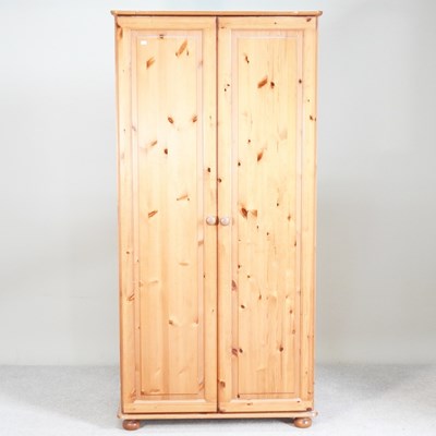Lot 570 - A modern pine double wardrobe, on turned feet