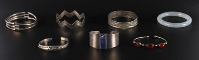 Lot 61 - A collection of silver and white metal bangles,...