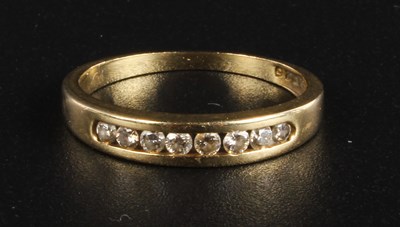 Lot 427 - A 9 carat yellow gold diamond channel set ring,...