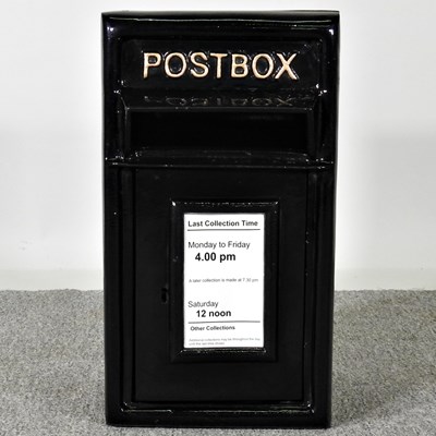 Lot 604 - A black painted metal post box, 58cm high
