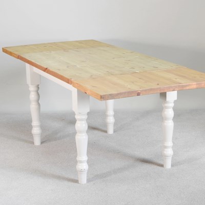 Lot 440 - A pine extending dining table, on a white...
