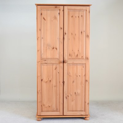 Lot 455 - A modern pine wardrobe, enclosed by a pair of...