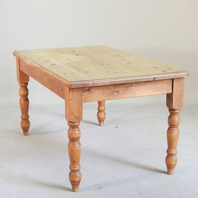 Lot 203 - A pine dining table, on turned legs, together...