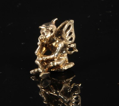 Lot 225 - A yellow metal figure of a seated pixie,...