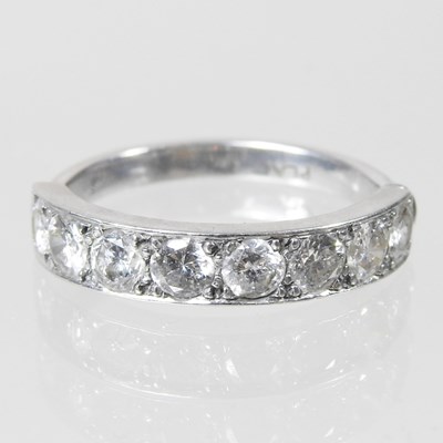 Lot 636 - A platinum and diamond half hoop eternity ring,...