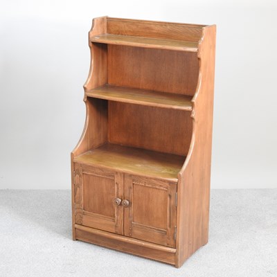 Lot 236 - An Ercol waterfall bookcase, with doors below