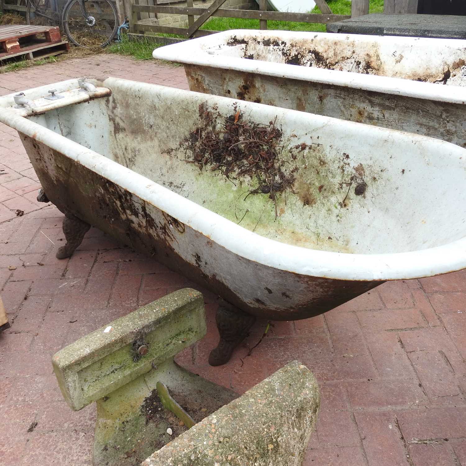 Lot 451 An antique cast iron roll top bath