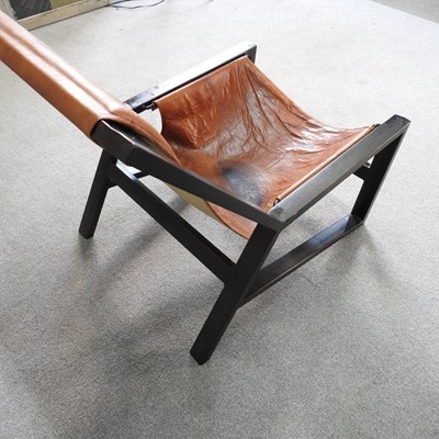 Lot 17 - A Nkuku mid century leather sling chair, with...