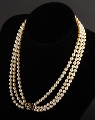Lot 141 - A cultured pearl three strand necklace, with a...