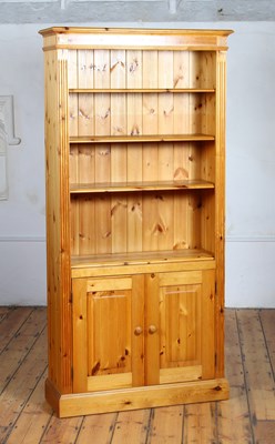 Lot 569 - A pine standing open bookcase, with doors below
