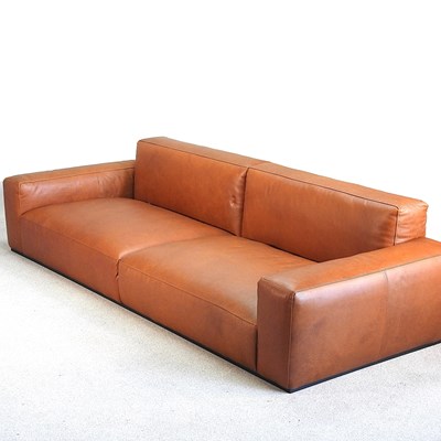 Lot 57 - A brown leather upholstered sofa, of...