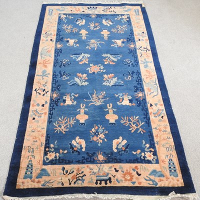 Lot 348 - A Chinese woollen rug, with traditional motifs,...