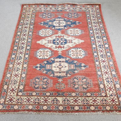 Lot 425 - A Kazak rug, with three central medallions, on...