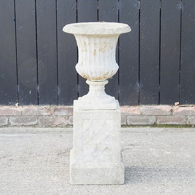 Lot 36 - A cast stone garden urn, on a plinth base,...
