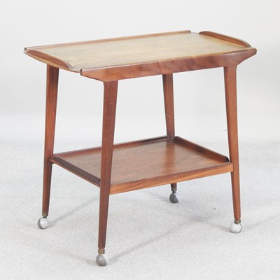 Lot 76 - A 1970s teak two tier tea trolley, on a...