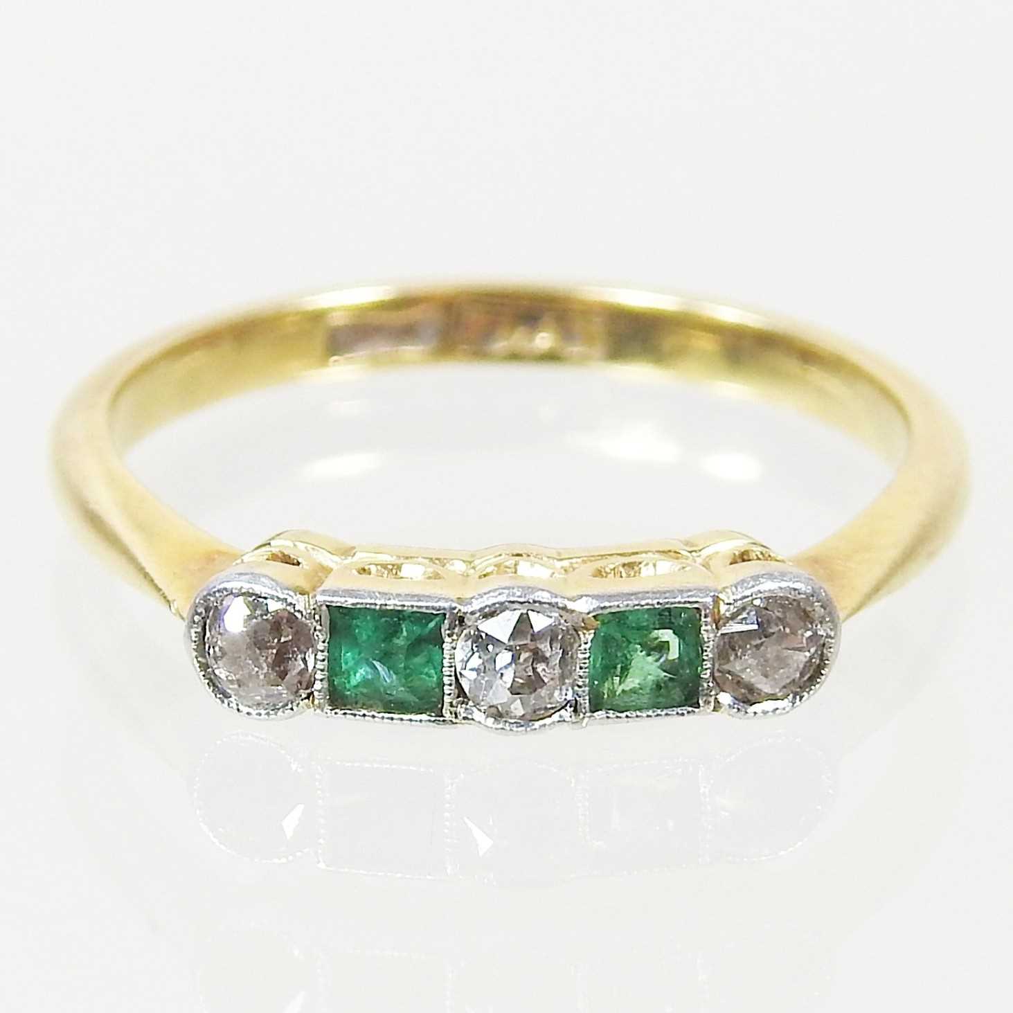 Lot 38 - A gold and platinum set five stone emerald and...