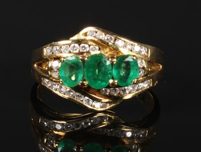 Lot 43 - A yellow metal emerald and diamond three stone...